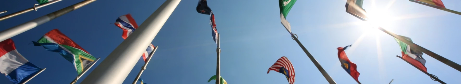 flagi różnych państw umieszczone na masztach